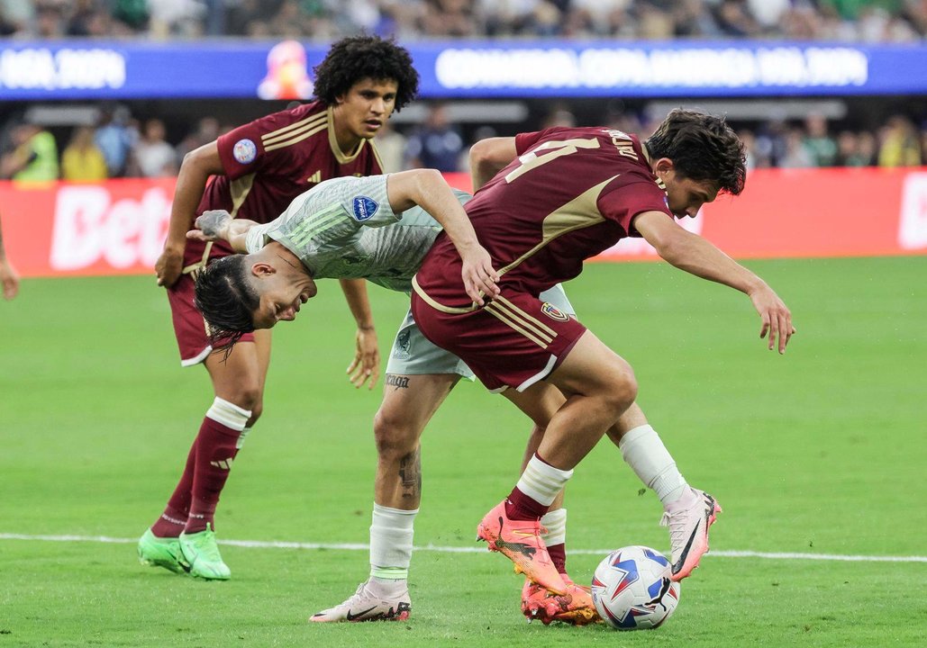 El defensa venezolano Jon Mikel Aramburu (d) fue registrado el pasado 26 de junio al disputar un balón con el lateral mexicano Gerardo Arteaga (c), durante un partido del grupo B de la Copa América 2024, en el SoFi Stadium de Inglewood (California, EE.UU.) EFE/Allison Dinner