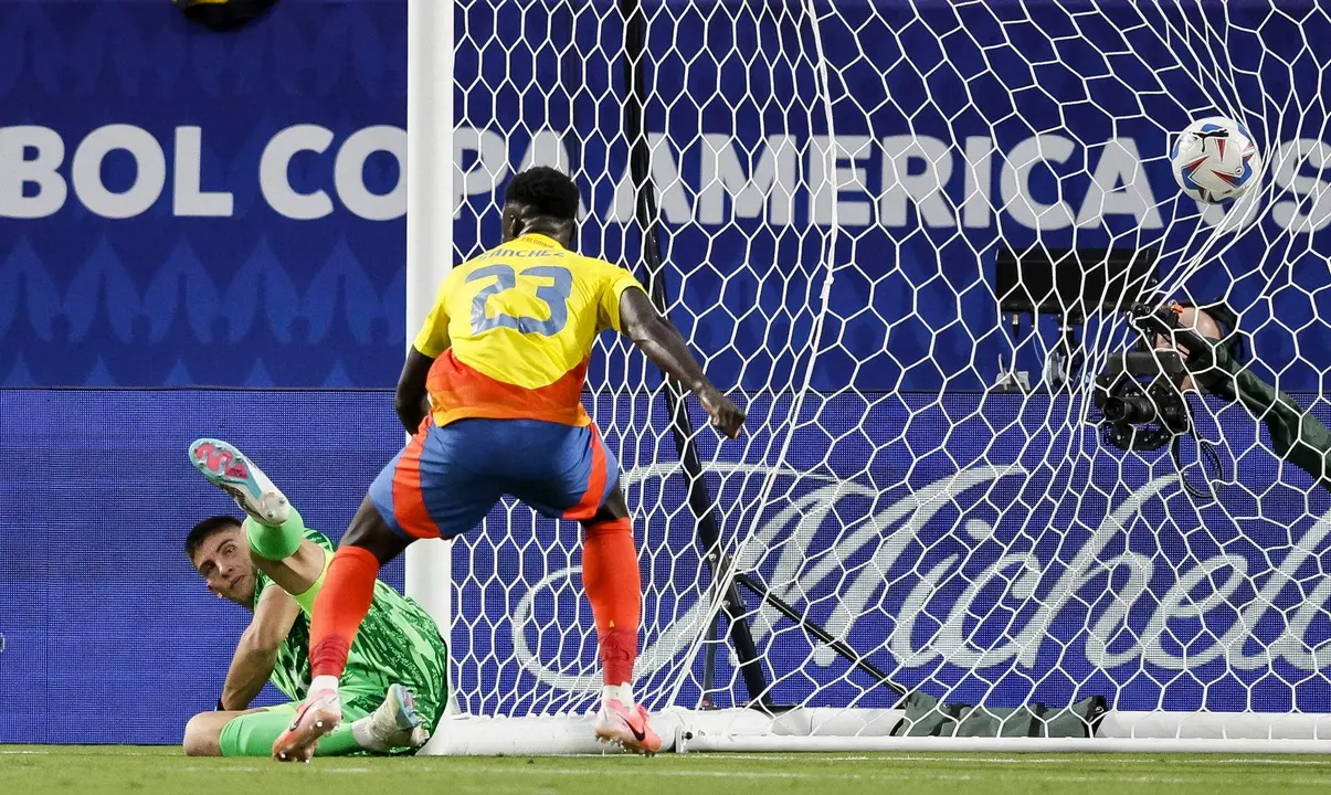 El defensor colombiano Davinson S&aacute;nchez fue registrado este mi&eacute;rcoles, 10 de julio, al observar el gol que su compa&ntilde;ero Jefferson Lerma (fuera de cuadro) le anot&oacute; a portero uruguayo Sergio Rochet (i), durante la segunda semifinal de la Copa Am&eacute;rica 2024, en el estadio Bank of America de Charlotte (Carolina de Norte, EE.UU.). EFE/Erik S. Lesser