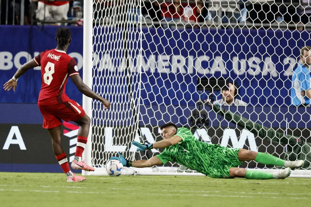El guardameta de la selecci&oacute;n uruguaya de f&uacute;tbol, Sergio Rochet (d), fue registrado este s&aacute;bado, 13 de julio, al detenerle un cobro de tiro penal al canadiense Ismael Kon&eacute;, durante la definici&oacute;n del partido por el tercer puesto de la Copa Am&eacute;rica 2024, en el estadio Bank of America de Charlotte (Carolina del Norte, EE.UU.). EFE/Erik S. Lesser