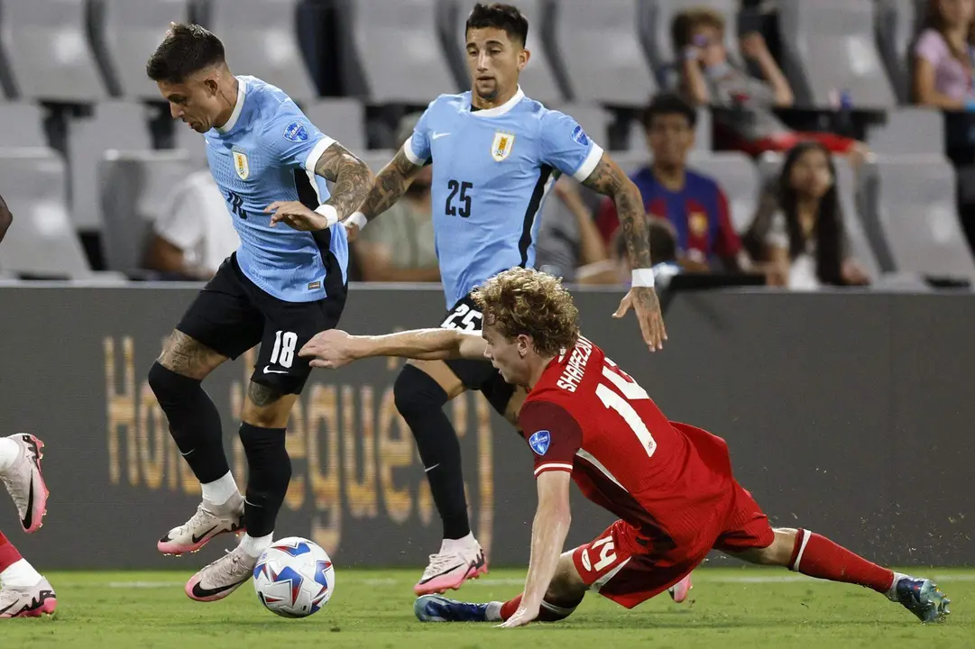 El delantero uruguayo Brian Rodr&iacute;guez (i), fue registrado este s&aacute;bado, 13 de julio, al intentar superar la marca del centrocampista canadiense Jacob Shaffelburg (d), durante el partido por el tercer puesto en la Copa Am&eacute;rica 2024, en el estadio Bank of America de Charlotte (Carolina del Norte, EE.UU.). EFE/Erik S. Lesser