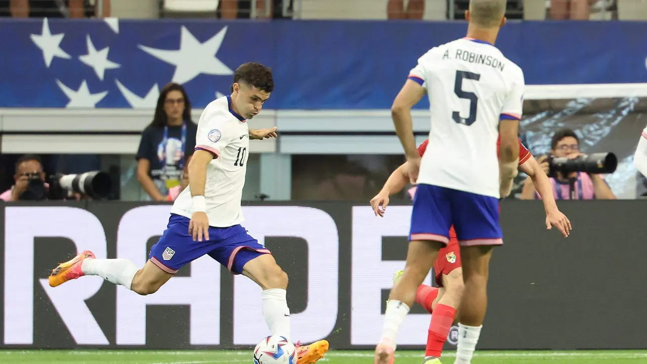 El atacante y capit&aacute;n de Estados Unidos, Christian Pulisic (i), fue registrado este domingo, 23 de junio, al disparar de derecha para marcar el primer gol del partido entre su selecci&oacute;n y la de Bolivia, que de momento es el m&aacute;s r&aacute;pido de la edici&oacute;n 48 de la Copa Am&eacute;rica (3 minutos), en el estadio AT&T de Arlington (Texas, EE.UU.). EFE/Kevin Jairaj