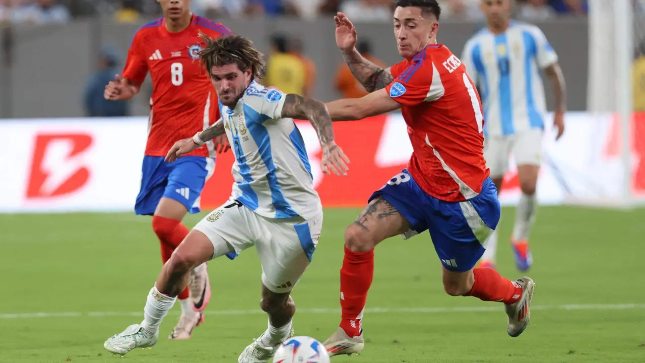 El centrocampista argentino Rodrigo de Paul (c-i) fue registrado este martes, 25 de junio, al disputar un bal&oacute;n el defensor chileno Rodrigo Echeverr&iacute;a (c-d), durante un partido de la fecha 2 del grupo A de la Copa Am&eacute;rica, en el estadio MetLife de East Rutherford (Nueva Jersey, EE.UU.). EFE/Justin Lane