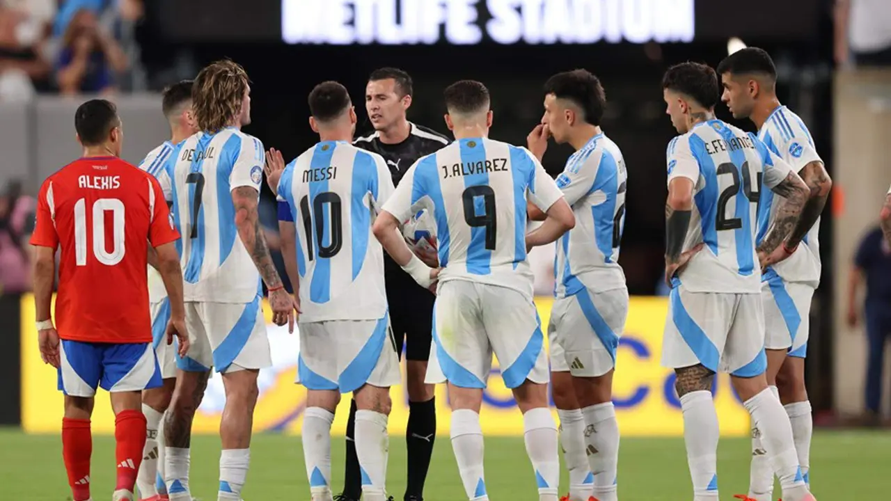 El &aacute;rbitro uruguayo Andr&eacute;s Matonte (c) fue registrado este martes, 25 de junio, al hablar con jugadores de la Albiceleste al esperar la decisi&oacute;n del VAR que valid&oacute; el gol que el argentino Lautaron Mart&iacute;nez le anot&oacute; a Chile, durante un partido de la fecha 2 del grupo A de la Copa Am&eacute;rica, en el estadio MetLife de East Rutherford (Nueva Jersey, EE.UU.). EFE/Justin Lane