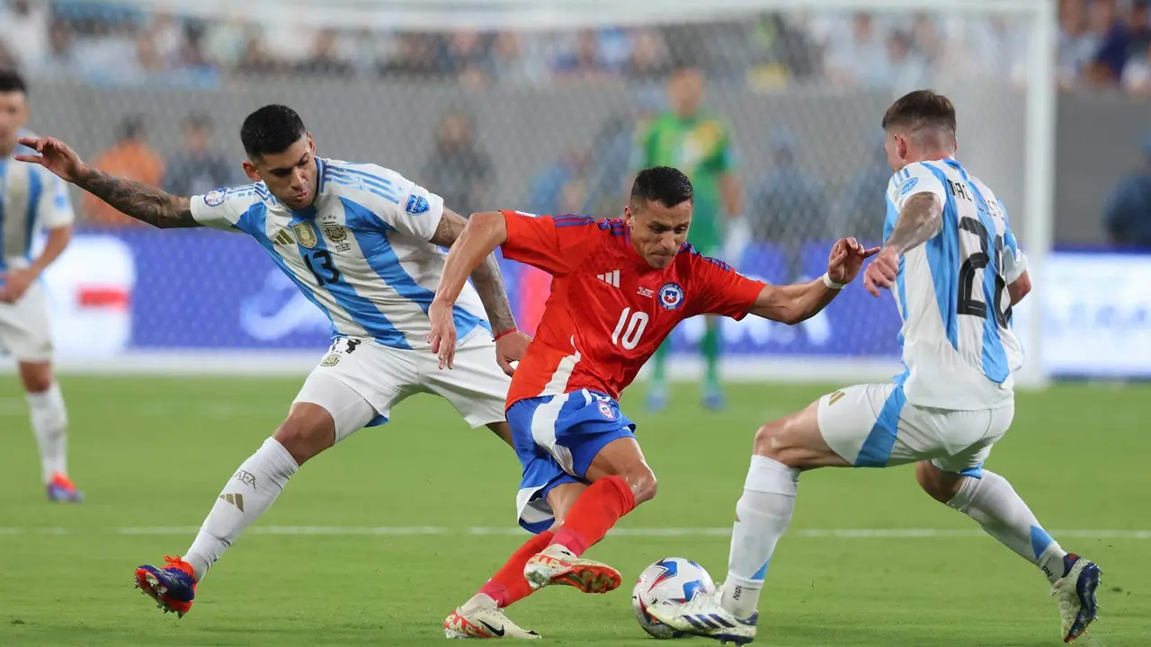 El defensor argentino Cristian Romero (i) y el centrocampista Alexis Mac Allister (d) desaf&iacute;an al delantero chileno Alexis S&aacute;nchez (C) durante la Copa Am&eacute;rica 2024. EFE/EPA/JUSTIN LANE
