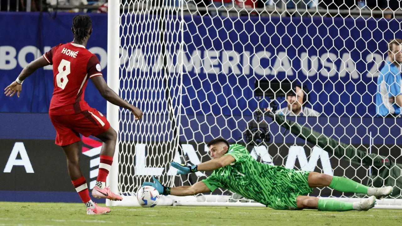 El guardameta de la selecci&oacute;n uruguaya de f&uacute;tbol, Sergio Rochet (d), fue registrado este s&aacute;bado, 13 de julio, al detenerle un cobro de tiro penal al canadiense Ismael Kon&eacute;, durante la definici&oacute;n del partido por el tercer puesto de la Copa Am&eacute;rica 2024, en el estadio Bank of America de Charlotte (Carolina del Norte, EE.UU.). EFE/Erik S. Lesser